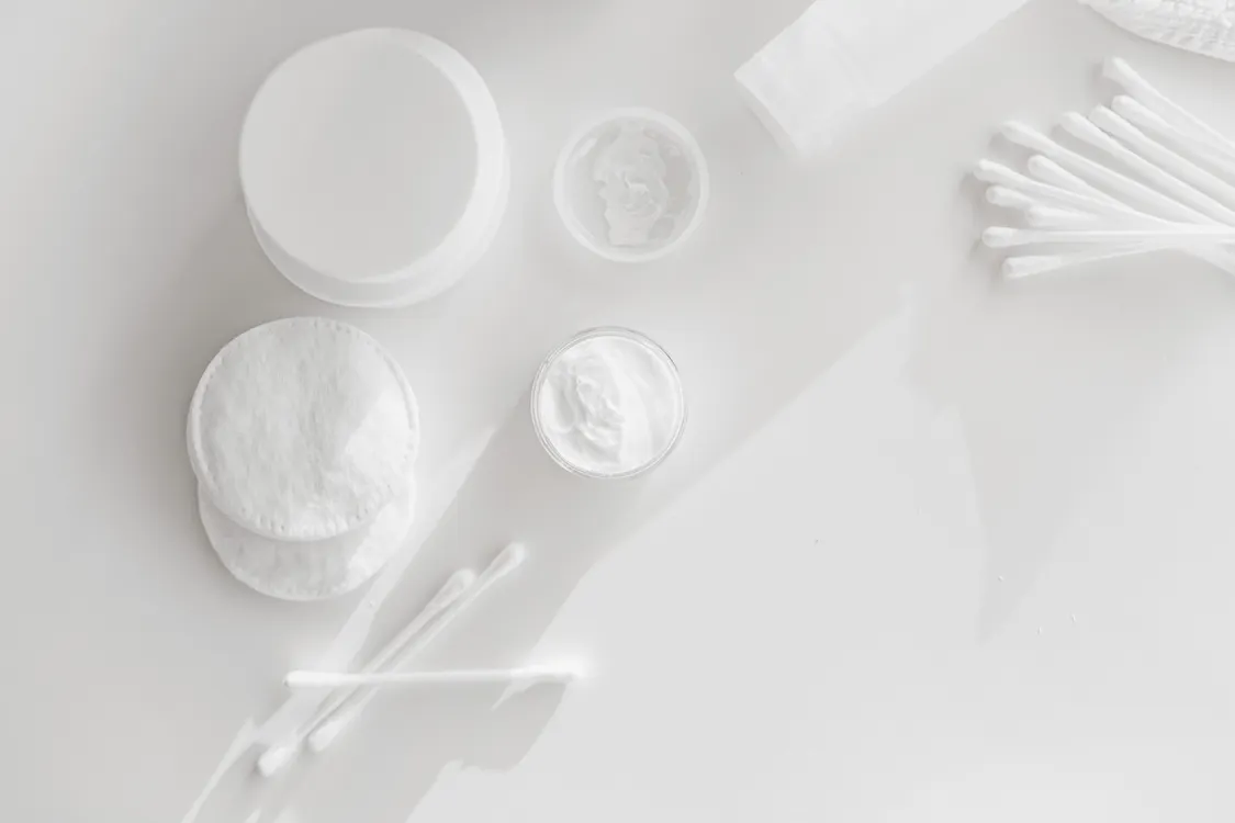 Skincare products arranged beside a mirror