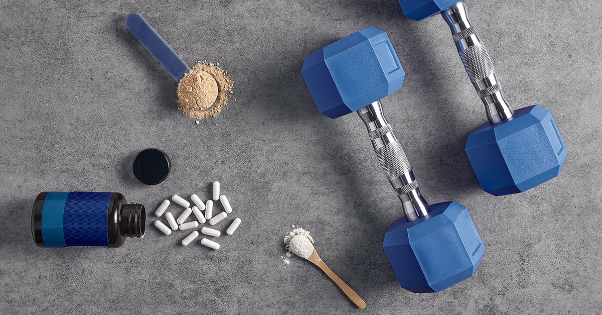 Workout supplements beside fresh foods and gym equipment